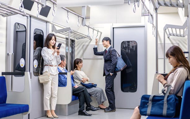 Passengers using mobile devices on a train in Japan.