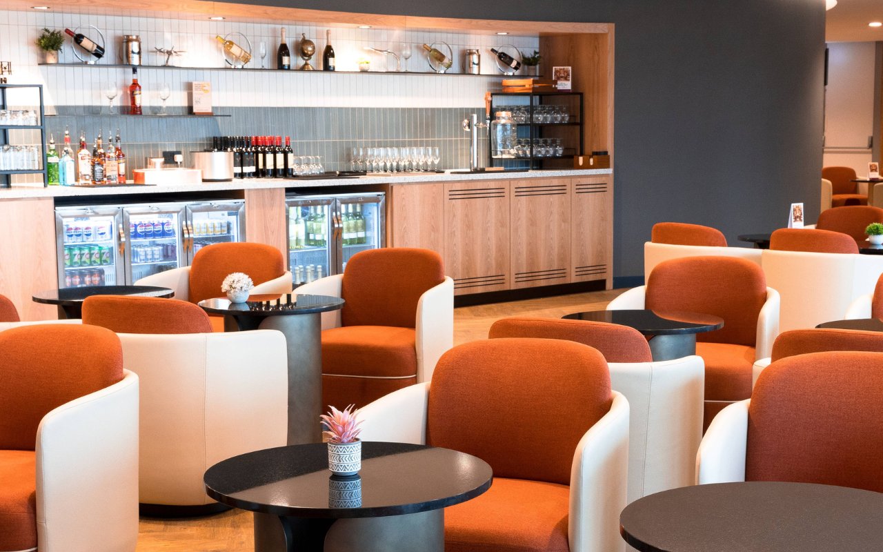 Plaza Premium Lounge seating area with bar at Terminal 4, London Heathrow Airport.