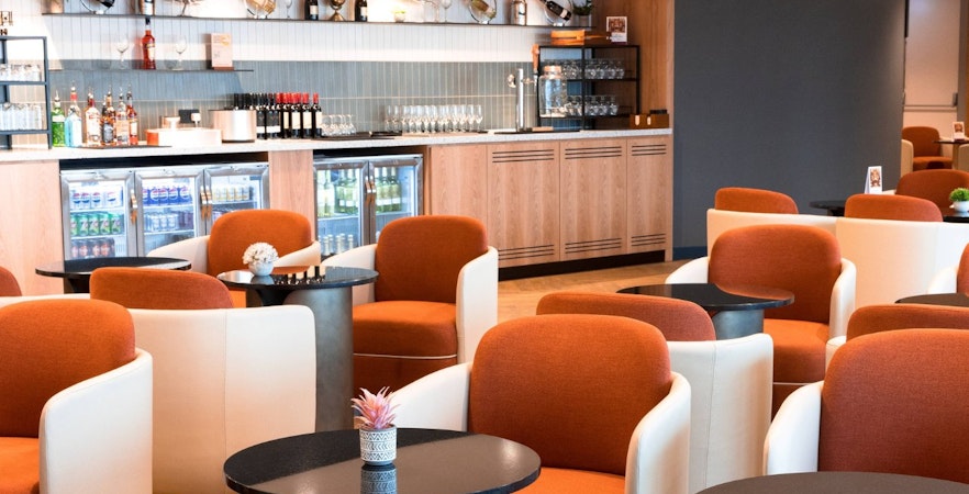 Plaza Premium Lounge seating area with bar at Terminal 4, London Heathrow Airport.