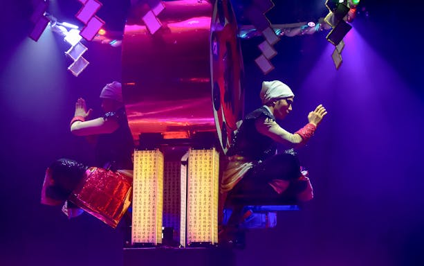 Performers in traditional attire during Samurai Restaurant Show in vibrant lighting.