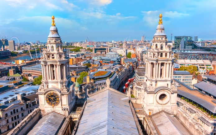 Aerial view from St Paul's Cathedral's Golden Gallery, showcasing twin baroque towers and London's skyline.