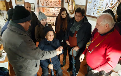 Group observing amber crafting demonstration at Gdańsk workshop.