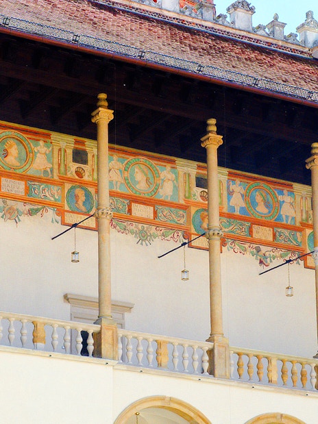 Wawel Cathedral's Renaissance courtyard with decorative frescoes and columns.