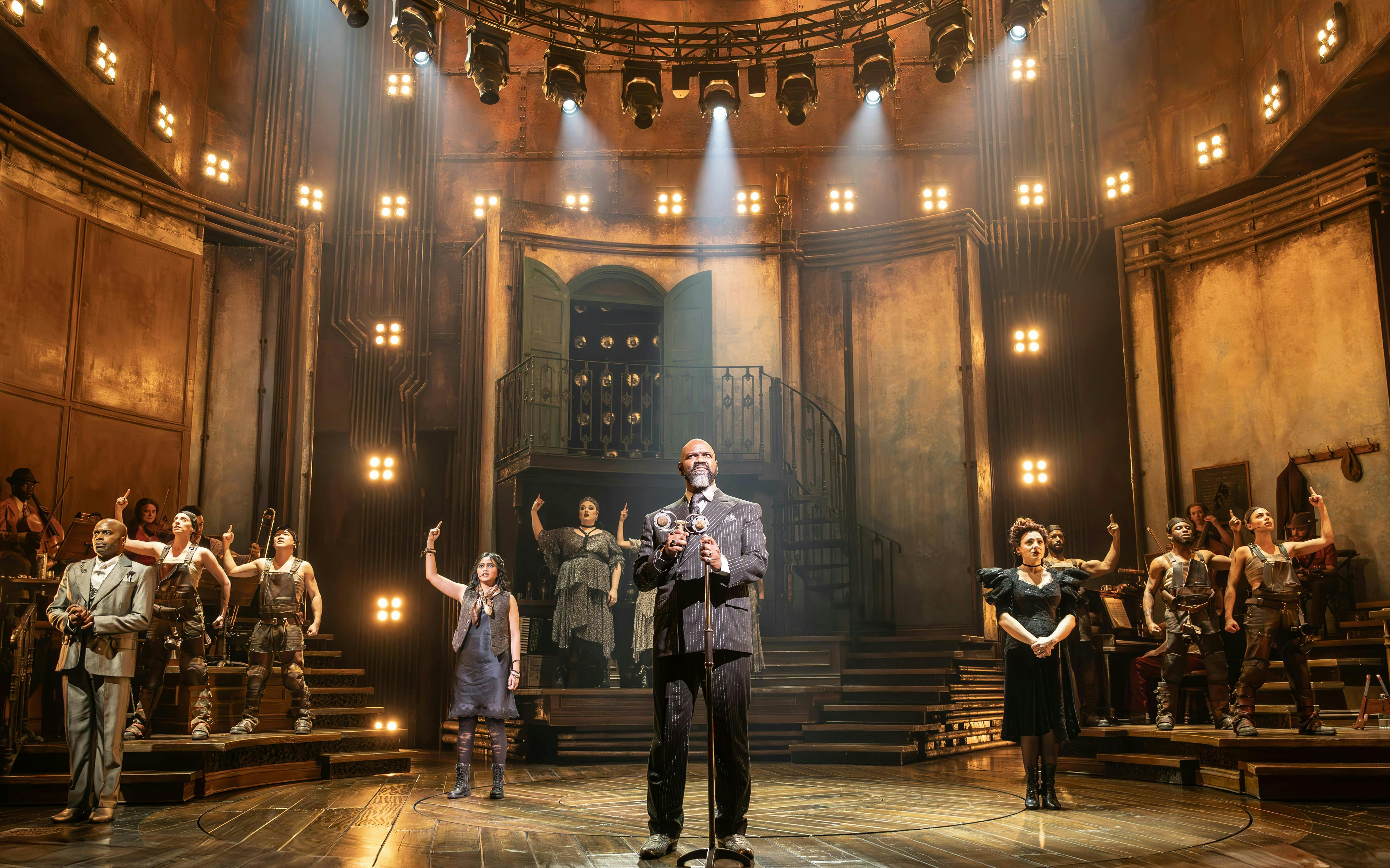 Stage performance of Hadestown in West End theater with cast on illuminated set.