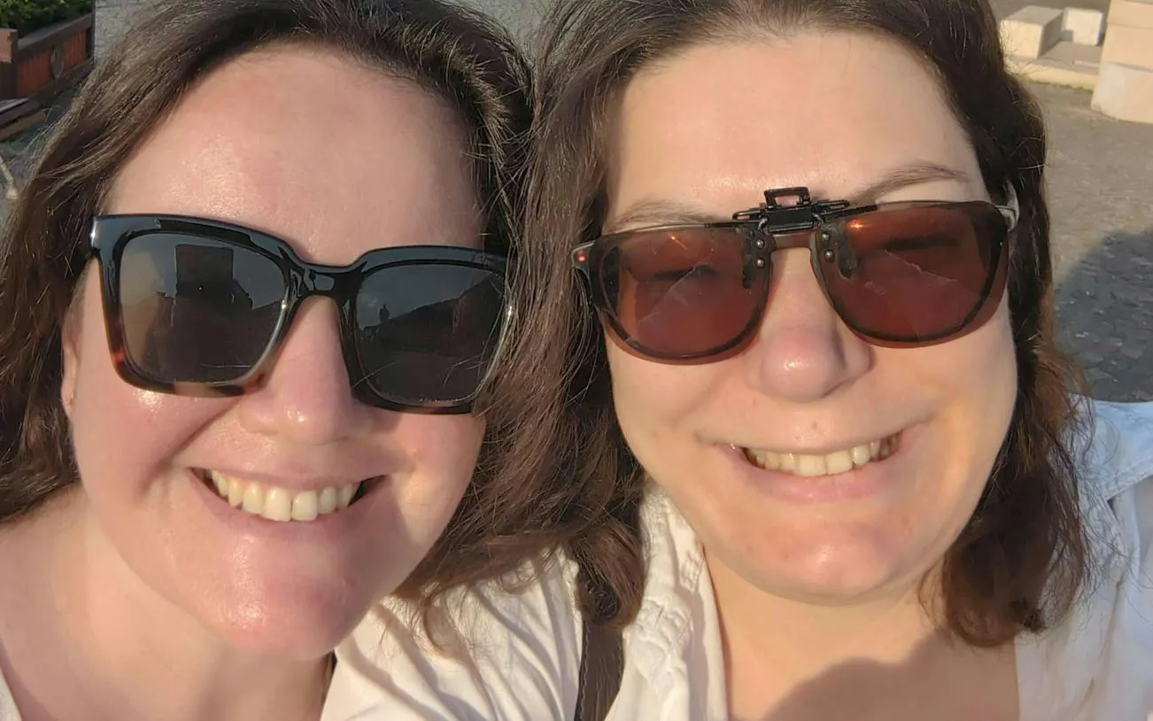 I don't know who these people are, but here's the alt text:

"Two people smiling during the Jewel of Brașov self-guided city exploration game.