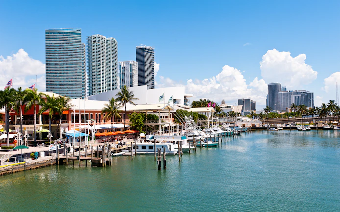 Bayside Marketplace marina with boats and Miami skyline in the background.