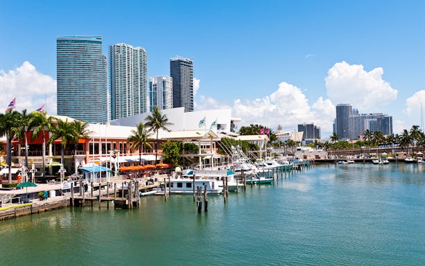 Bayside Marketplace marina with boats and Miami skyline in the background.