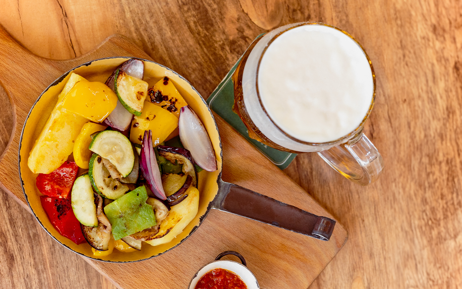 Grilled vegetables and beer on a wooden table, part of Prague lunch tour.