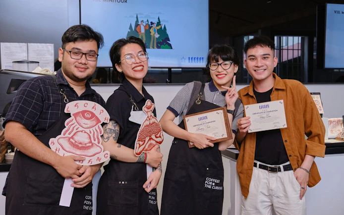 Participants holding certificates at a Vietnamese coffee workshop in Hồ Chí Minh City.