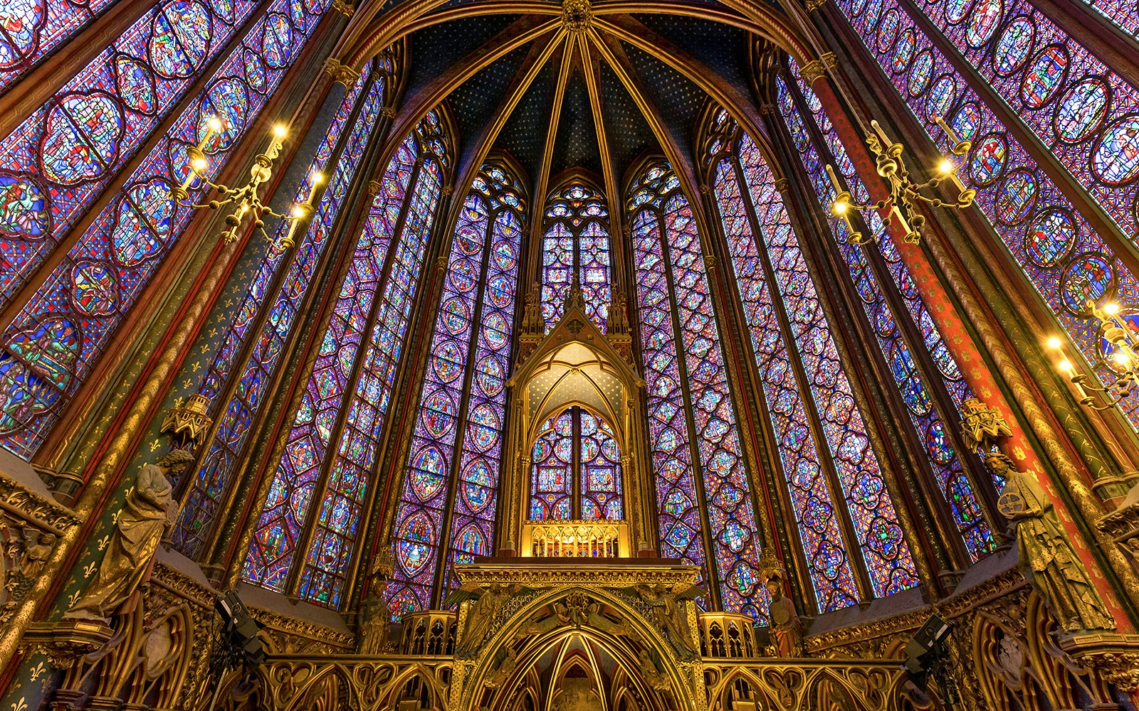 Stained glass windows inside Sainte Chapelle, Paris, showcasing biblical scenes.