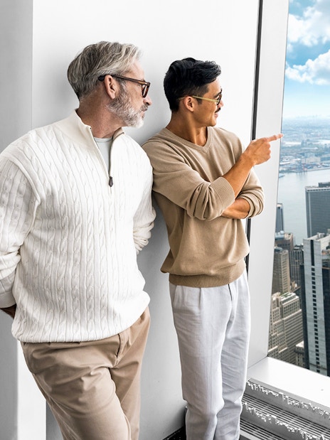 Visitors enjoying the view from One World Observatory, overlooking New York City skyline and harbor.