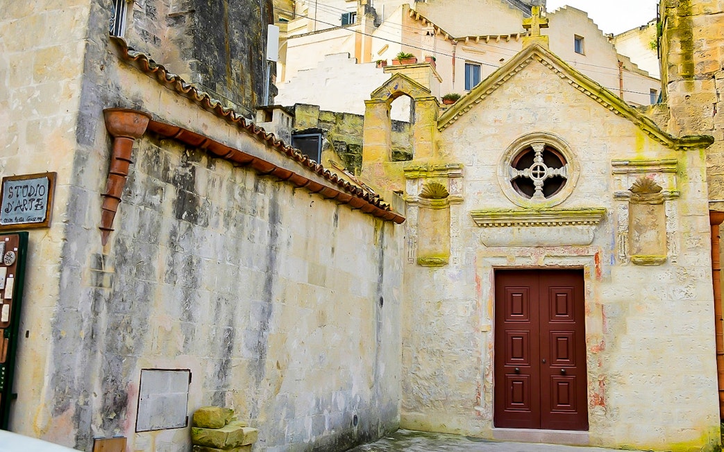 Facade of historic building in Sassi of Matera during guided tour.