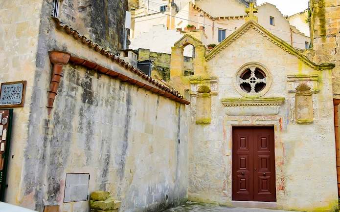 Facade of historic building in Sassi of Matera during guided tour.