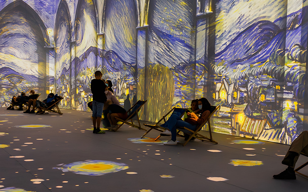 Guests viewing Van Gogh projections at London exhibition.