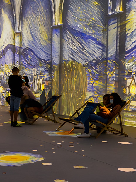 Guests viewing Van Gogh projections at London exhibition.