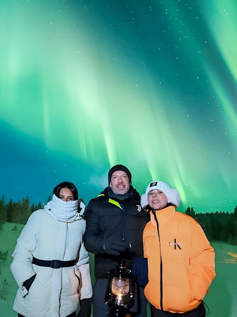 Guests viewing Northern Lights on a snowy landscape during Discovery Tour.