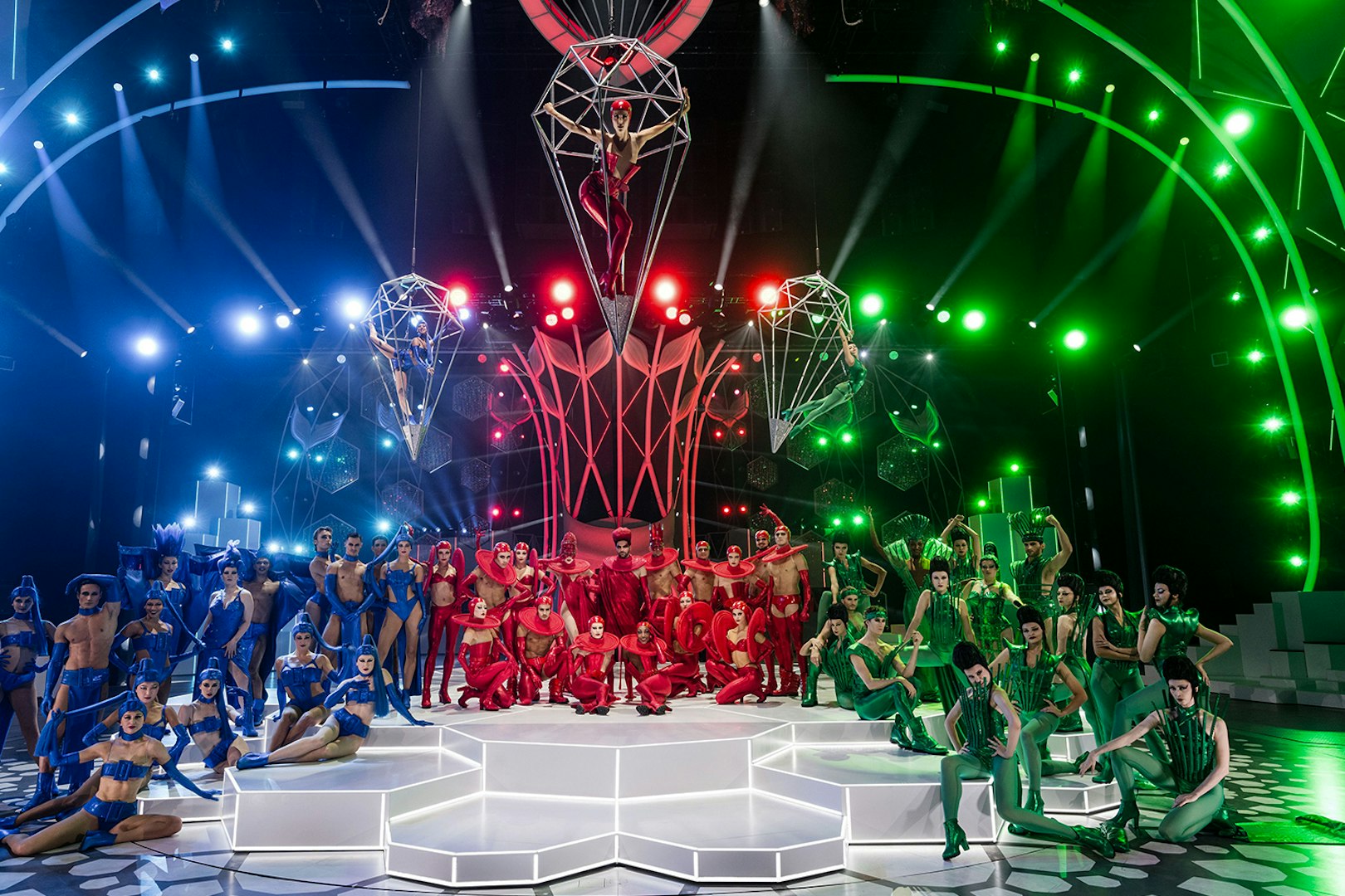 Performers in colorful costumes on stage at the FALLING | IN LOVE Grand Show, Friedrichstadt Palast.