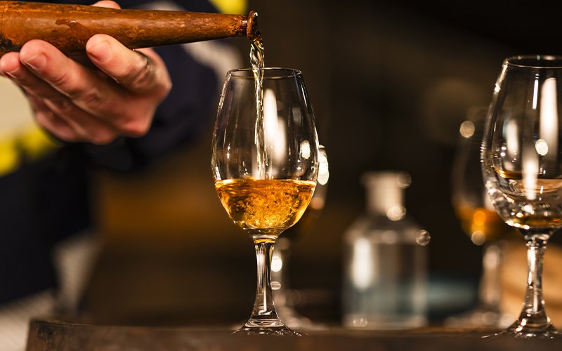 Pouring whiskey into a glass during the Midleton Distiller’s Apprentice Tour.