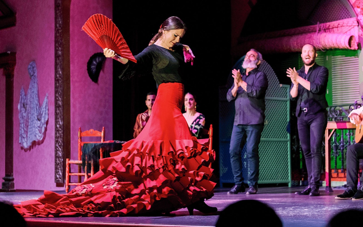 Flamenco dancer performing with a red fan at Only Flamenco, Seville.