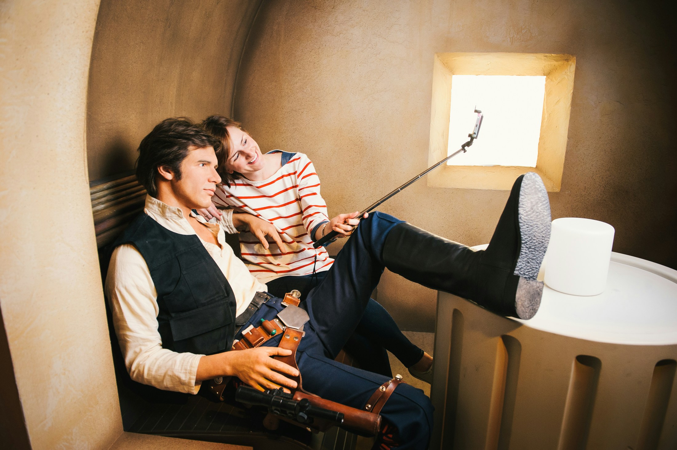 Visitor taking selfie with Han Solo wax figure at Star Wars exhibit, Madame Tussauds London.