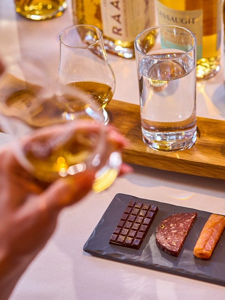 Whiskey tasting with chocolate, salami, salmon, and cheese pairing.