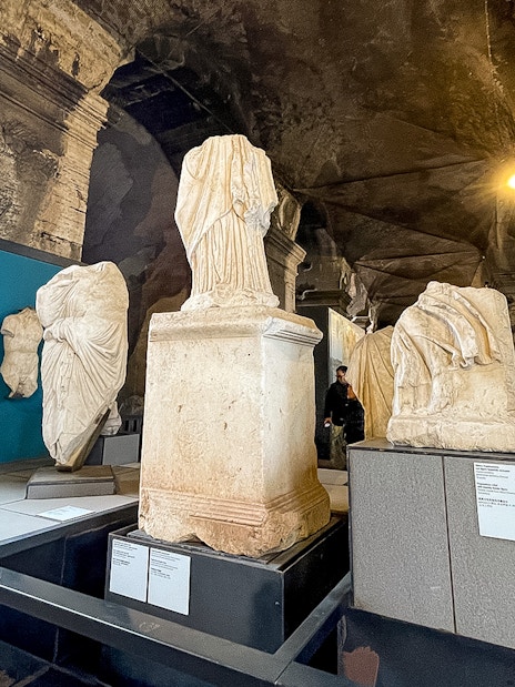 Ancient Roman statues displayed inside the Colosseum Museum in Rome.