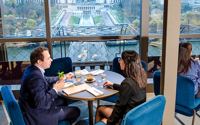 Couple dining at Madame Brasserie with view of Trocadéro Gardens, Paris.