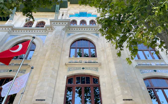 Facade of Hagia Sophia Museum with Turkish flags and intricate architectural details.