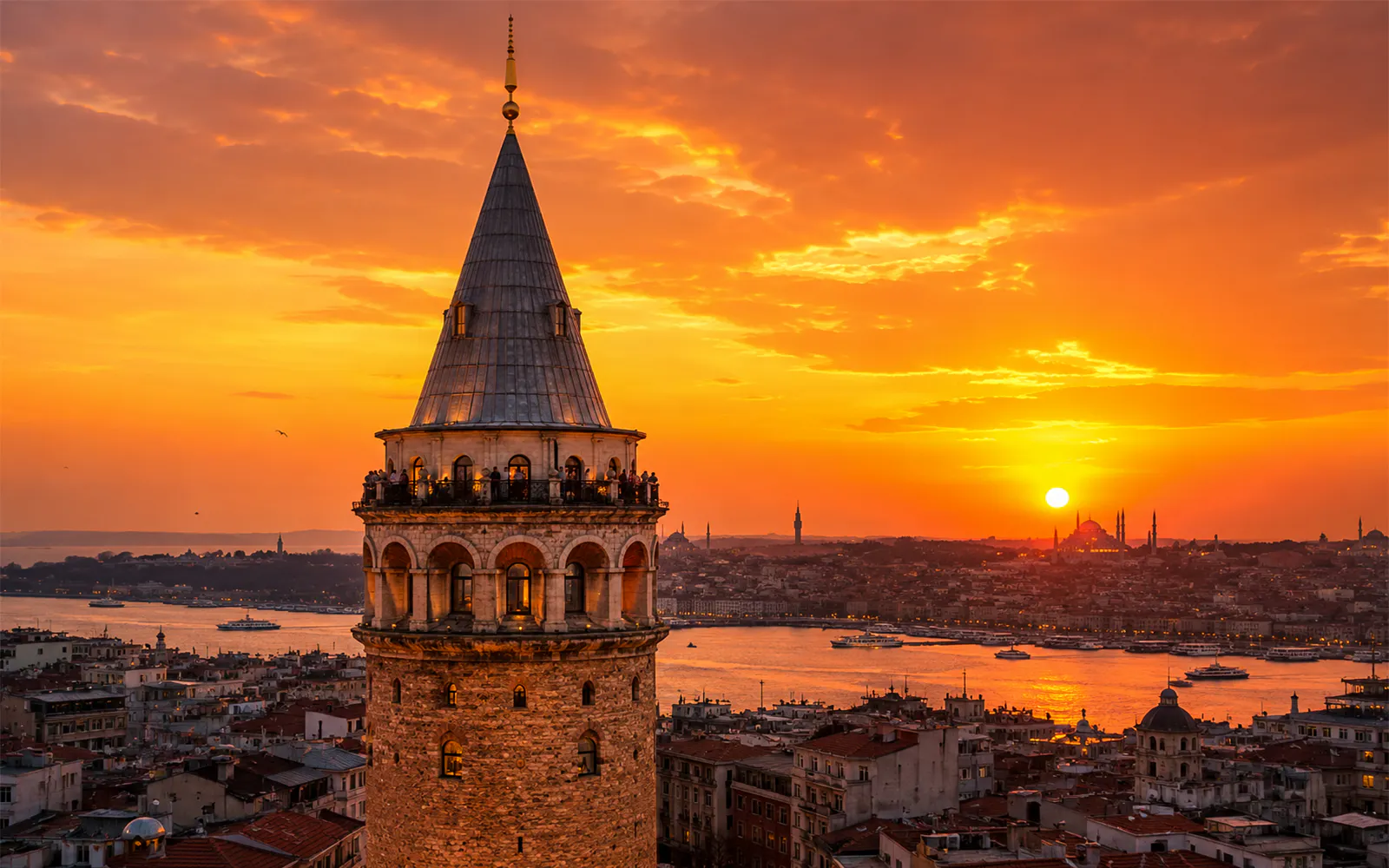Galata Tower overlooking Istanbul at sunset with cityscape and Bosphorus views.