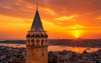 Galata Tower overlooking Istanbul at sunset with cityscape and Bosphorus views.