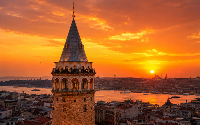 Galata Tower overlooking Istanbul at sunset with cityscape and Bosphorus views.