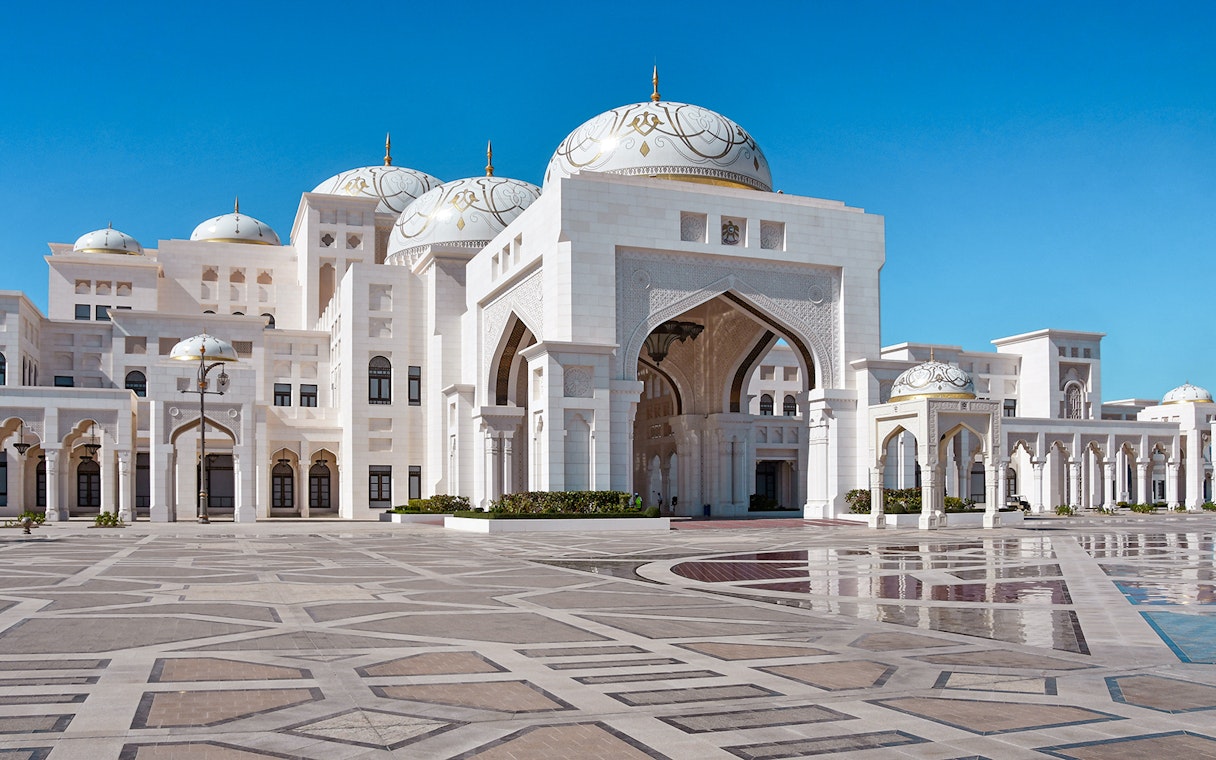 Abu Dhabi's Qasr Al Watan palace with intricate domes and arches on a clear day.