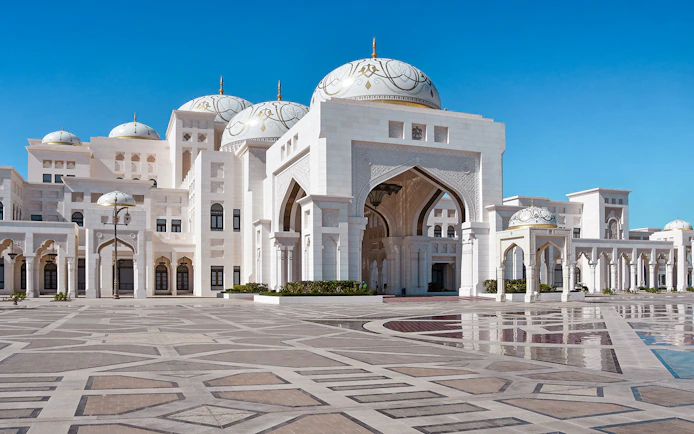 Abu Dhabi's Qasr Al Watan palace with intricate domes and arches on a clear day.