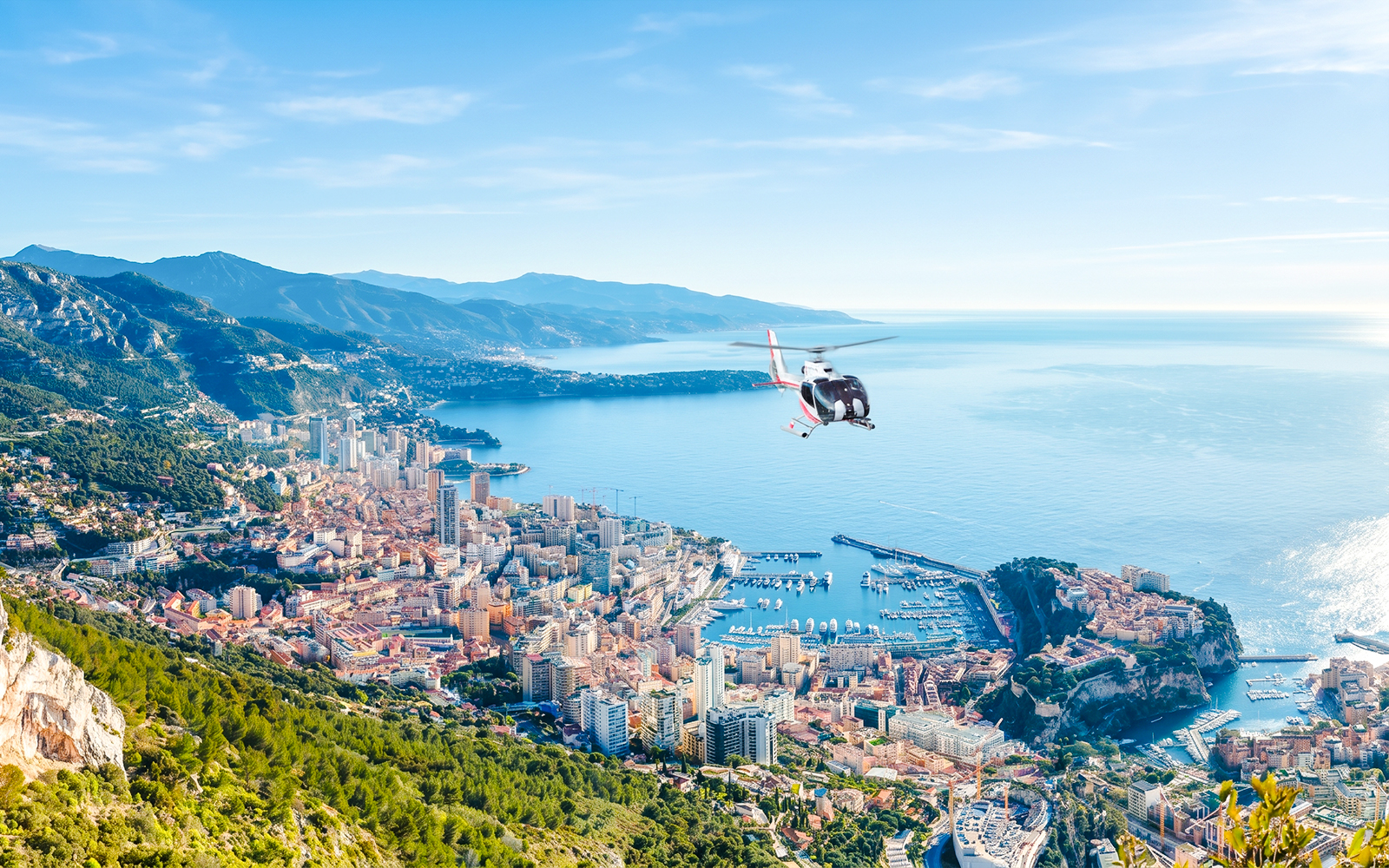 Helicopter flying over Monaco coastline during panoramic tour.