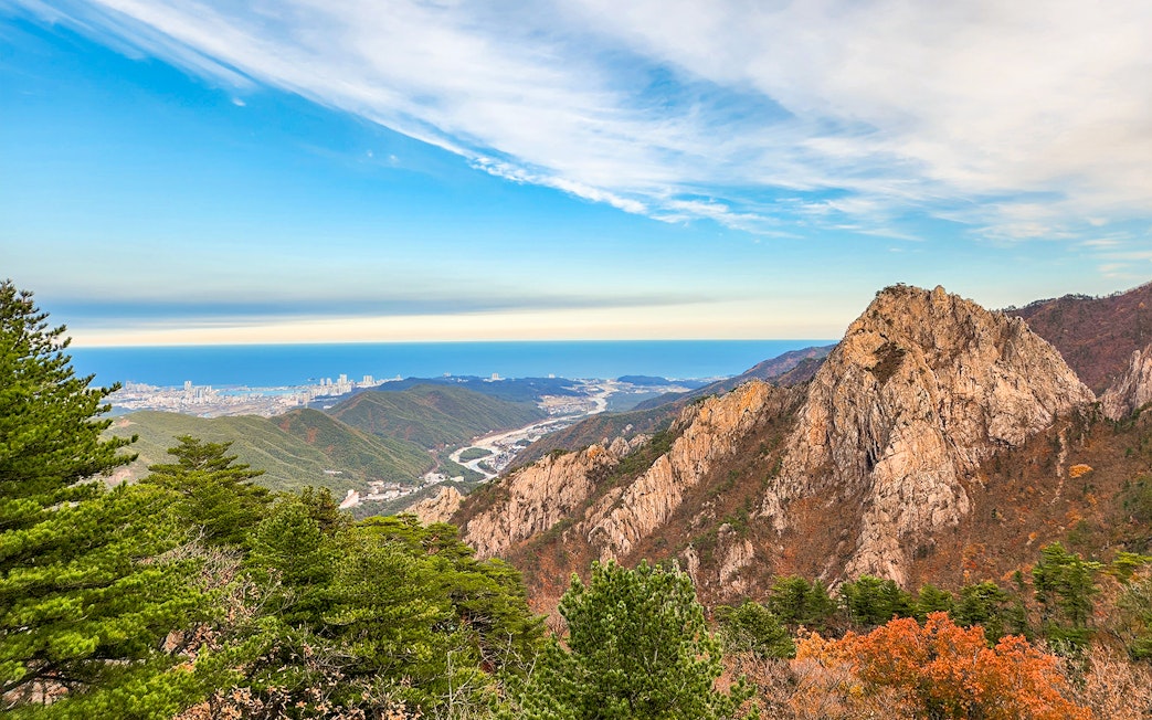 Seorak mountain peak with rocky formations and distant city view in South Korea.