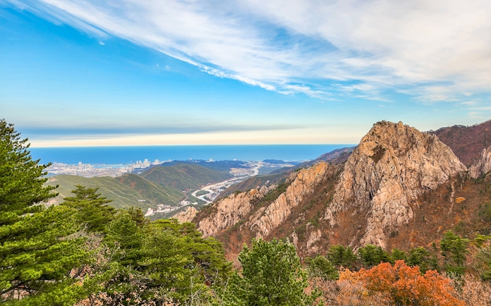 Seorak mountain peak with rocky formations and distant city view in South Korea.