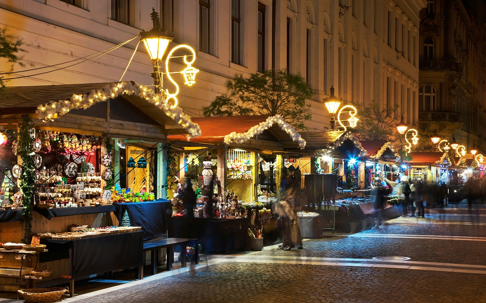 Budapest Christmas market stalls lit up at night in December.