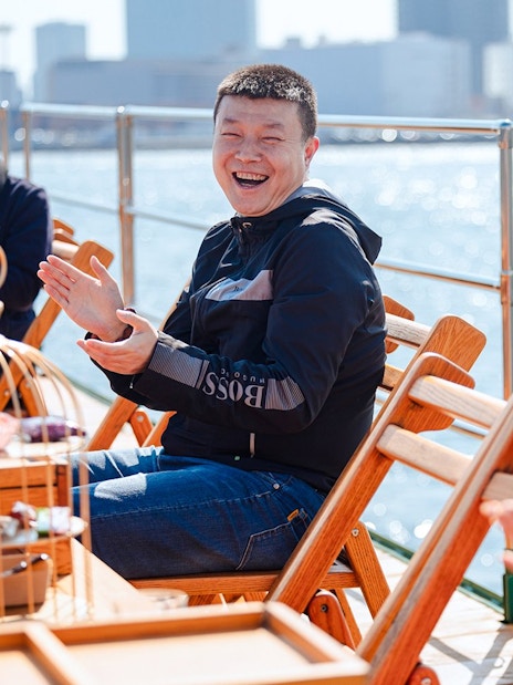 Tourists clapping and enjoying on deck of Yakatabune Cruise in Tokyo Bay.