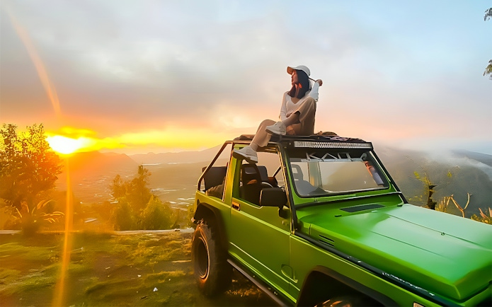 Person sitting on a green jeep at Mount Batur sunrise, Bali.
