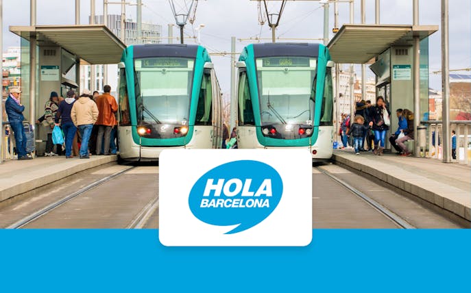 Trams at a Barcelona station with passengers boarding, Hola Barcelona logo displayed.