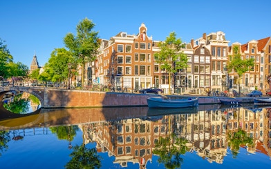 Prinsengracht canal with historic buildings and boats in Amsterdam city.