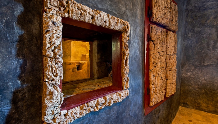 Convento dos Capuchos stone archway surrounded by lush greenery in Sintra, Portugal.