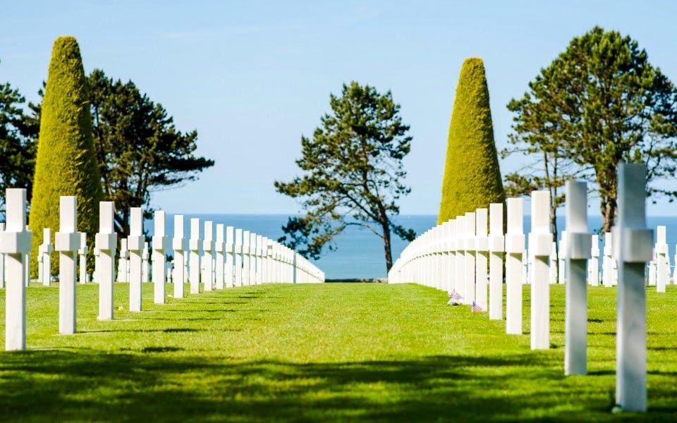 Rows of white crosses at Normandy American Cemetery, Colleville-sur-Mer, overlooking the sea.