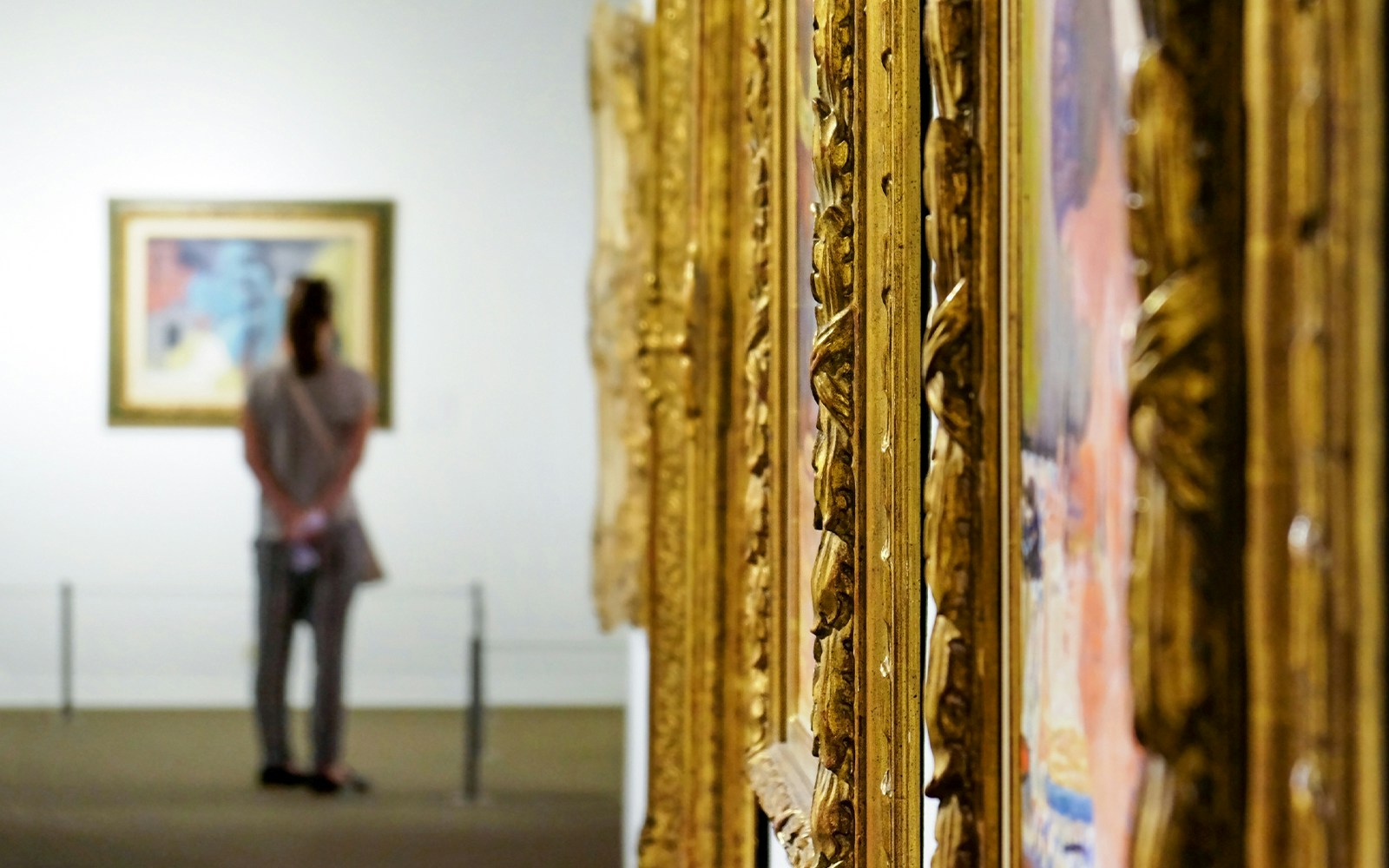 Visitor observing artwork in a museum gallery.