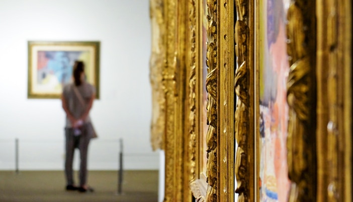 Visitor in museum viewing a painting in in Accademia Gallery