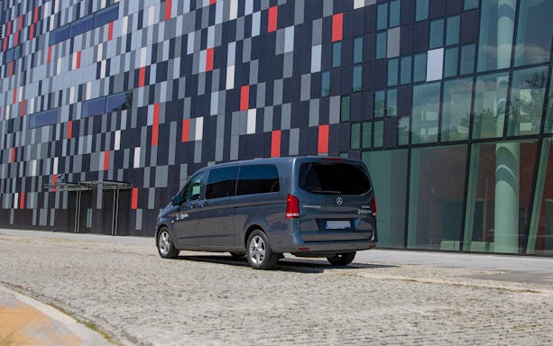 Shuttle van parked outside modern building for Krakow Balice-Krakow City Airport Transfer.