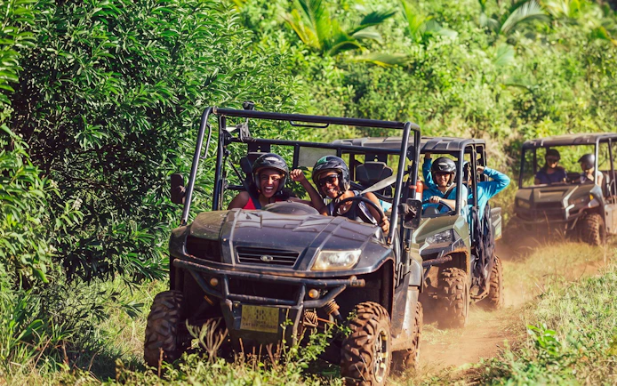 Group enjoying Bel Ombre buggy tour through lush greenery.