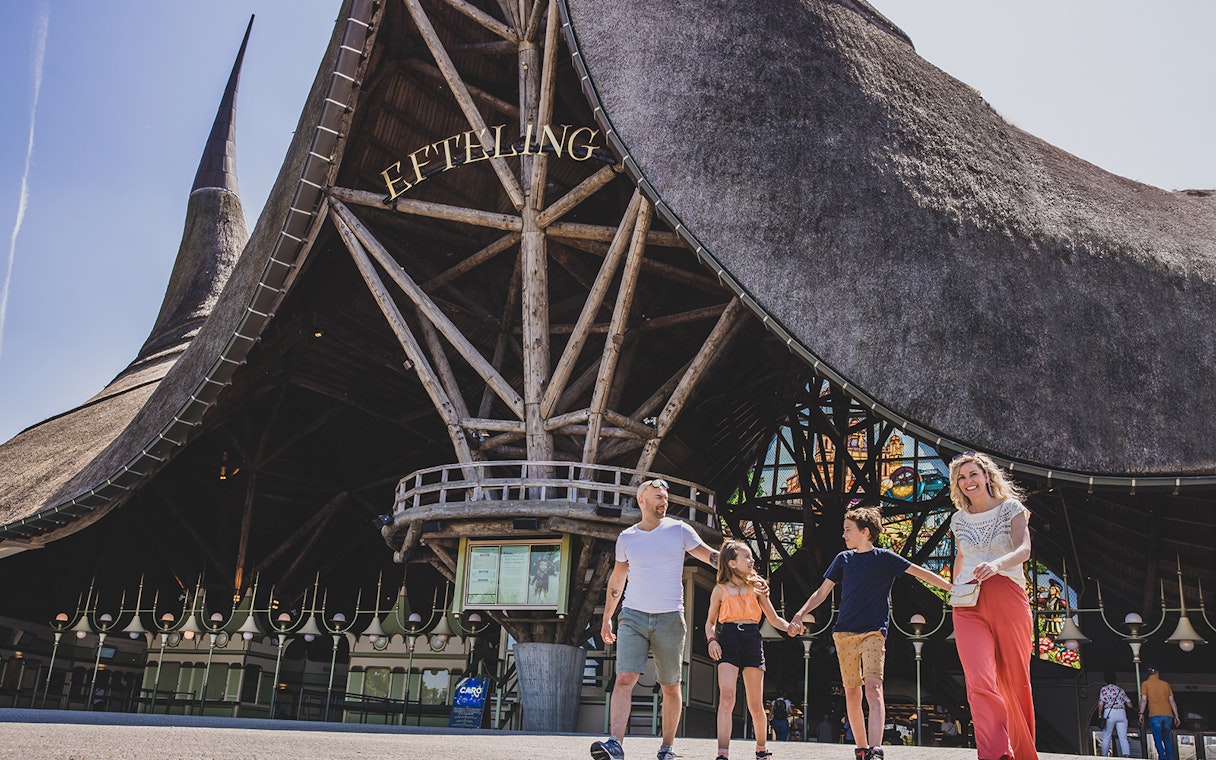 Family walking in front of Efteling theme park entrance, Netherlands.