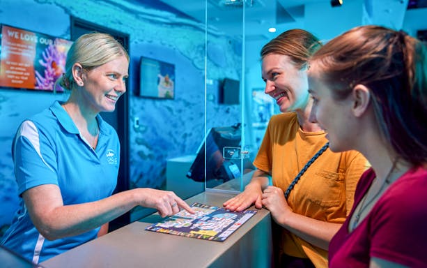 Cairns Aquarium staff assisting visitors with Living Coral Biobank tour information.
