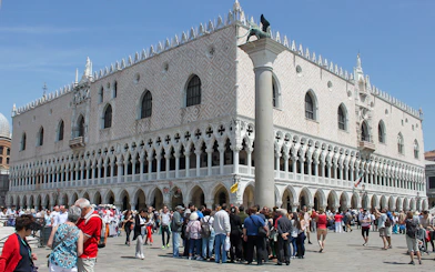 Tourists gather outside Doge's Palace in Venice during a walking tour.
